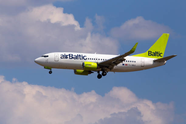 YL-BBJ Air Baltic Boeing 737-300 aircraft on the cloudy sky background stock photo
