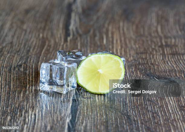 Cubes Of Ice And Slice Of Lime In A Wooden Table Stock Photo - Download Image Now - Citrus Fruit, Clean, Close-up