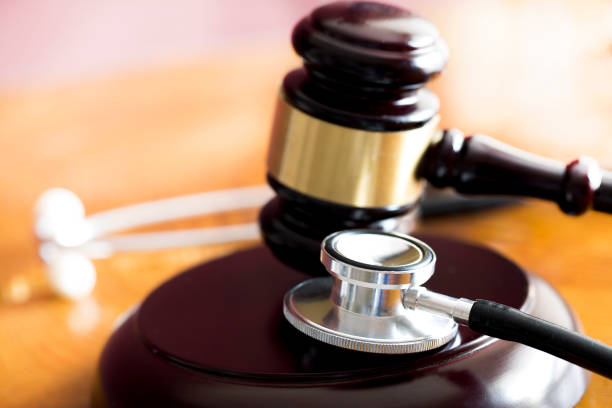Medical law concept. Gavel and stethoscope on wooden table stock photo