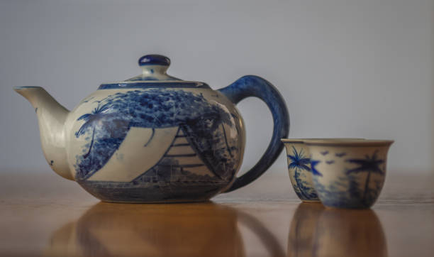 istock Blue and white china teapot with two matching cups 965375328