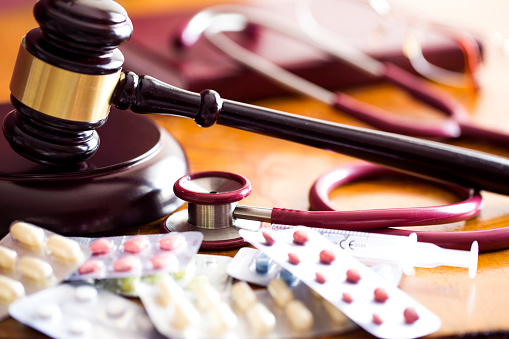 Drug law concept. Judges gavel with  stethoscope  and pills close up