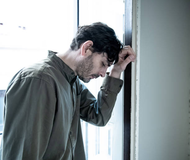 istock Lonely young man looking outside house balcony looking depressed, destroyed, sad and suffering emotional crisis and grief thinking of taking a difficult and important life decision 965380948