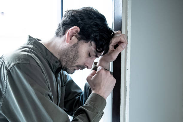 istock Lonely young man looking outside house balcony looking depressed, destroyed, sad and suffering emotional crisis and grief thinking of taking a difficult and important life decision 965380950