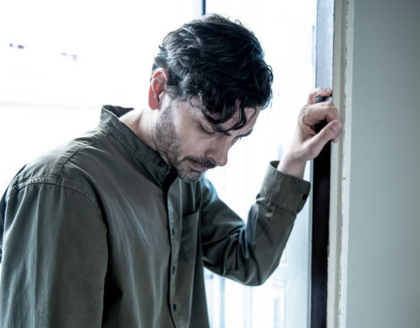 istock Lonely young man looking outside house balcony looking depressed, destroyed, sad and suffering emotional crisis and grief thinking of taking a difficult and important life decision 965380954