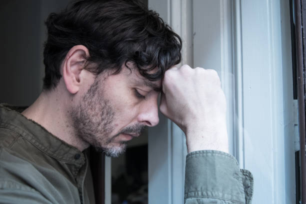 istock Lonely young man looking outside house balcony looking depressed, destroyed, sad and suffering emotional crisis and grief thinking of taking a difficult and important life decision 965380984