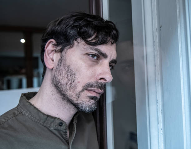 istock Lonely young man looking outside house balcony looking depressed, destroyed, sad and suffering emotional crisis and grief thinking of taking a difficult and important life decision 965380994