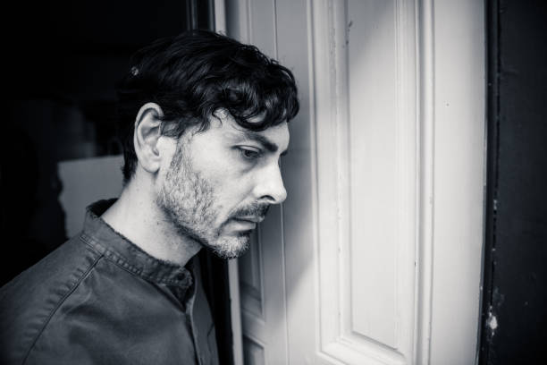 istock Lonely young man looking outside house balcony looking depressed, destroyed, sad and suffering emotional crisis and grief thinking of taking a difficult and important life decision 965381032