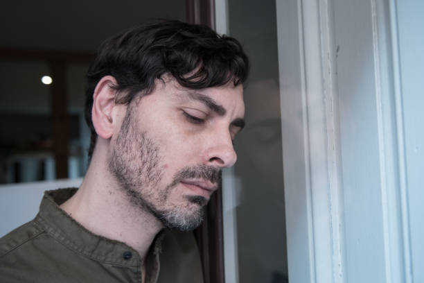 istock Lonely young man looking outside house balcony looking depressed, destroyed, sad and suffering emotional crisis and grief thinking of taking a difficult and important life decision 965381038