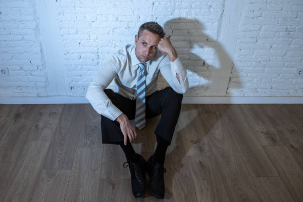 istock depressed business man feeling sad, lonely and suffering from anxiety leaning on a white wall at home in mental health depression concept 965384330