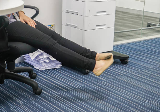 businesswoman take off her shoes to relax on her chair in office stock photo