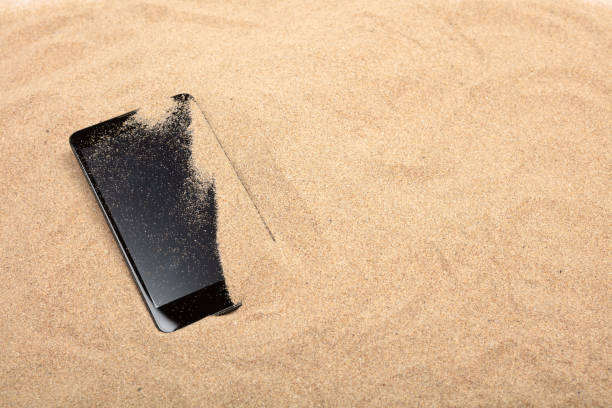 Close up smart phone on sand beach texture background. Copy space of technology and travel nature concept