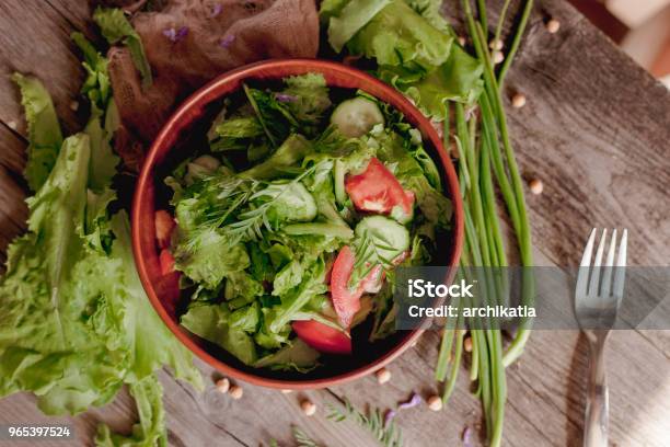 Salad Of Fresh Tomato Cucumber Lettuce And Onion On A Plate On A Table Stock Photo - Download Image Now