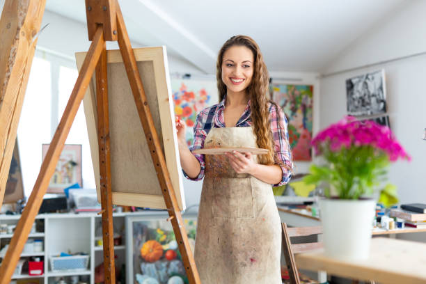 istock Young female painter drawing flowers in atelier 965403388