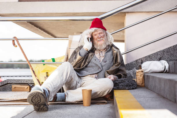 istock Cheerful street beggar making a call 965408960
