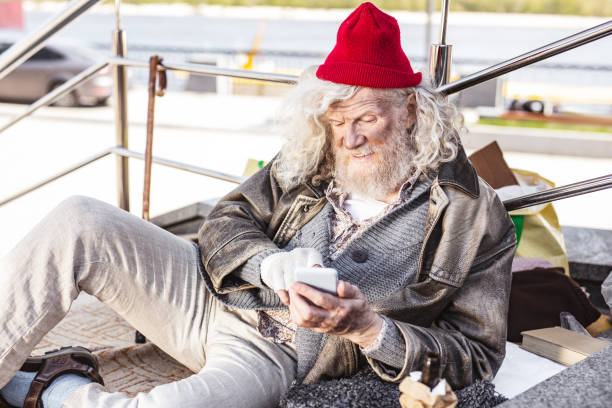 istock Positive homeless man enjoying new technology 965409558