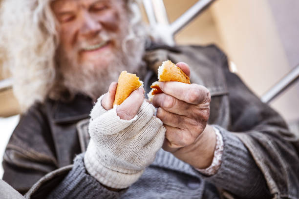 My food. Selective focus of tasty bread being in hands of a hungry homeless man