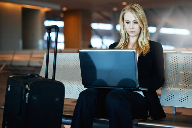istock Woman working on laptop computer at airport 965412108