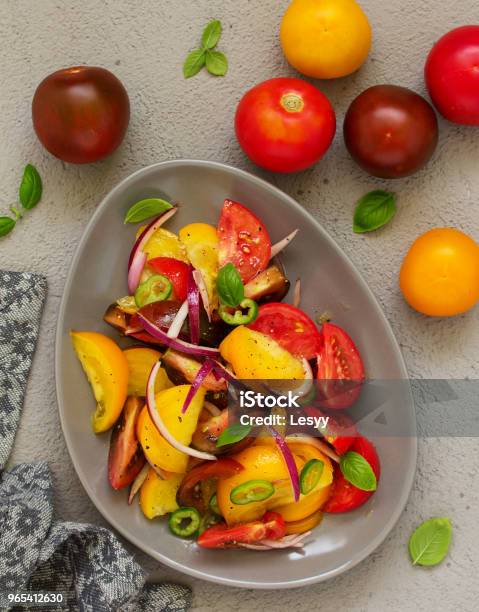 Vegetarian Salad With Fresh Tomato With Red Onion Basil And Olive Oil Stock Photo - Download Image Now