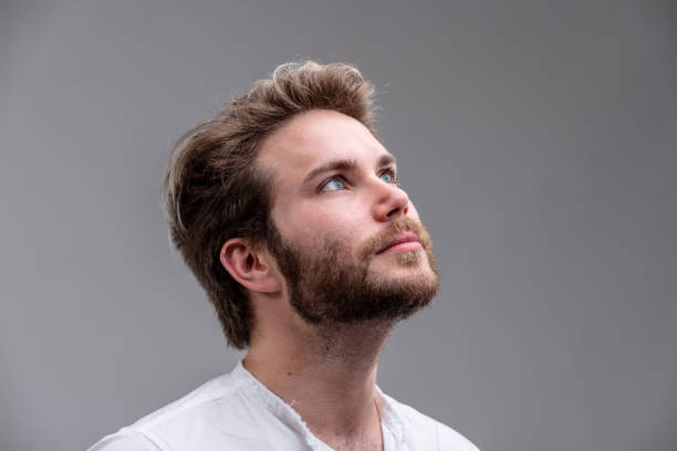 istock Young man looking up while thinking of a new idea 965420690