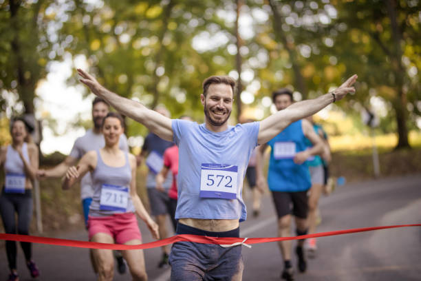 istock Successful marathon runner crossing finish line in nature. 965421134