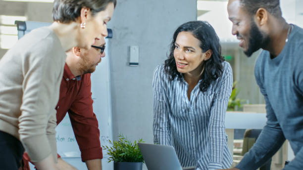 istock Diverse Group of Young Professionals Surround Conference Table and Collectively Try to Solve Problem. 965424580