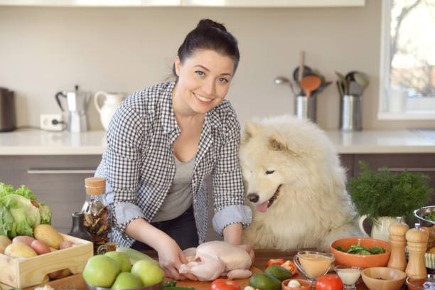 istock woman cooking in the kitchen ( with dog) 965424832