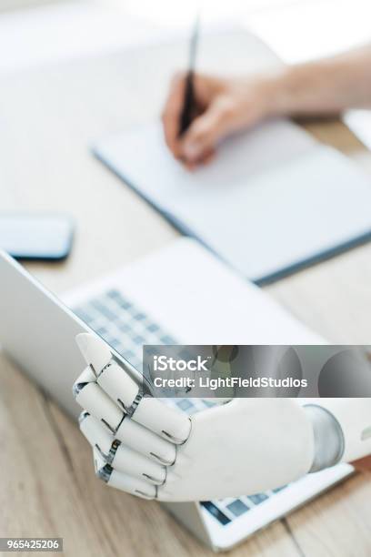 Robotic Hand Notes Closeup View Of Robotic Arm Using Laptop And Human Hand Taking Notes At ...