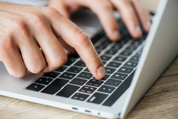 istock close-up partial view of person typing on laptop, selective focus 965428308