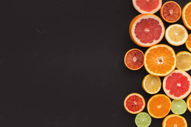 istock Variety of ripe citruses on black background 965428610