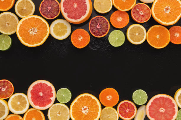 istock Variety of ripe citruses on black background 965428648