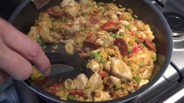 Paella with rice, seafood: shrimps and mussels cooking at home.