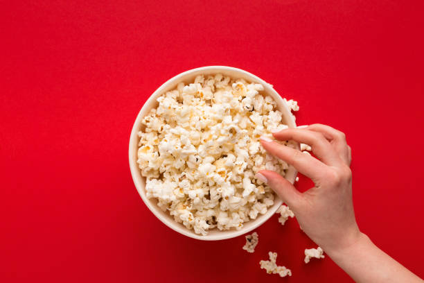 istock Bucket of popcorn on red background, top view 965433034