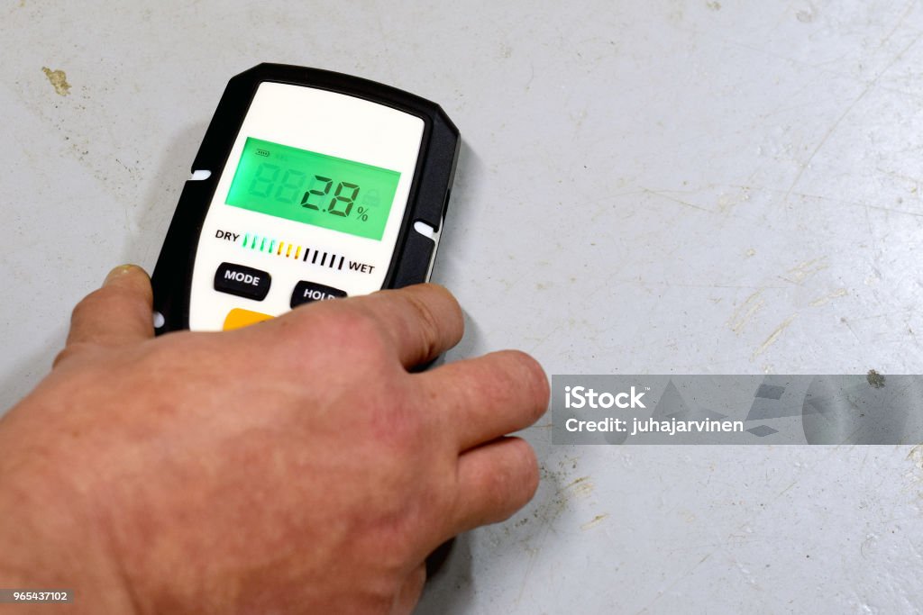 Moisture measuring Measuring moisture in concrete floor. Space for text. Wet Stock Photo