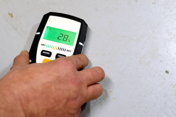 Moisture measuring Measuring moisture in concrete floor. Space for text. wet stock pictures, royalty-free photos & images