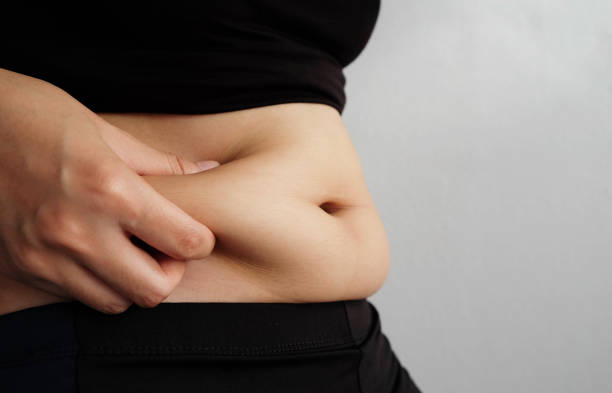 istock Side of woman hand catching fat body belly paunch , diabetic risk factor 965444476