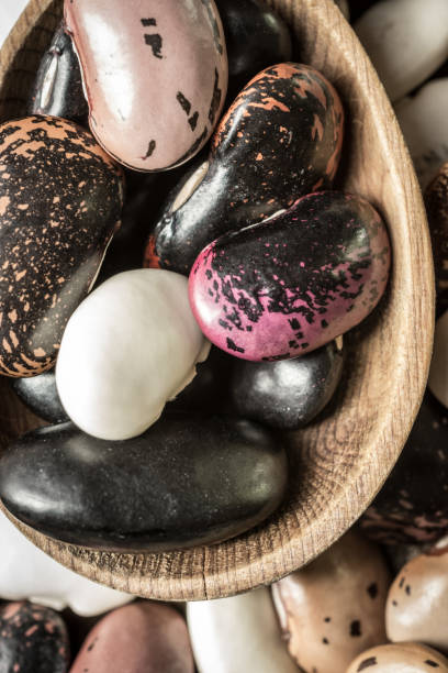 istock Raw Colorful Beans and Wooden Spoon on Dark Background 965444884