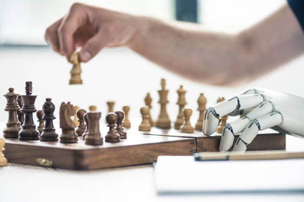 istock close-up view of person and robotic arm playing chess 965447778