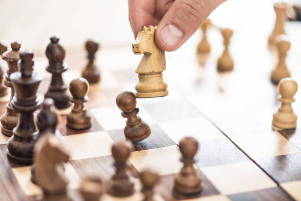 istock cropped shot of human hand playing chess, selective focus 965448290