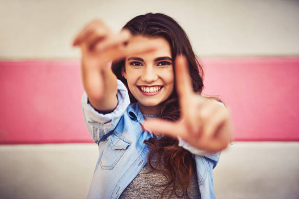 Just picture yourself being happy in your life Portrait of a beautiful young woman posing against a wall outside hand cropping photos stock pictures, royalty-free photos & images