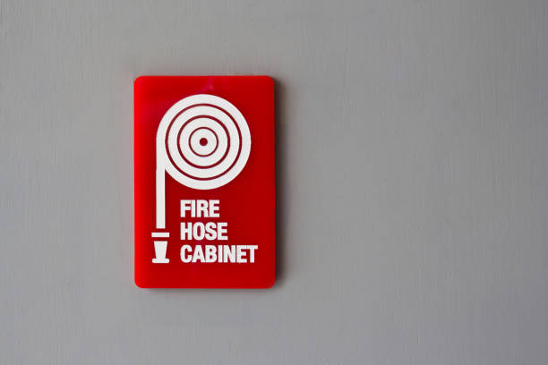 red fire hose cabinet sign on grey wooden wall background