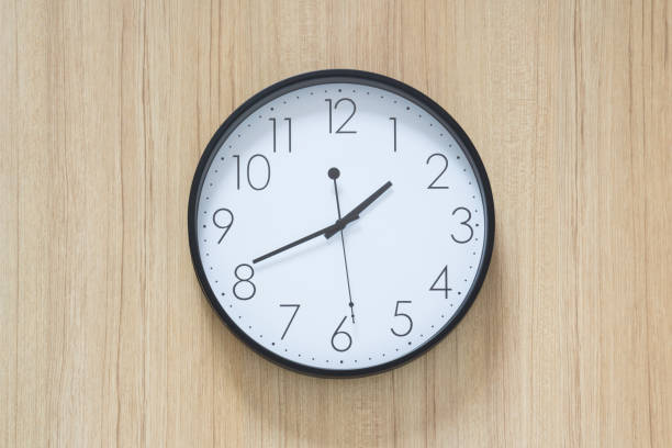 istock black and white clock hangs on wooden wall 965461842