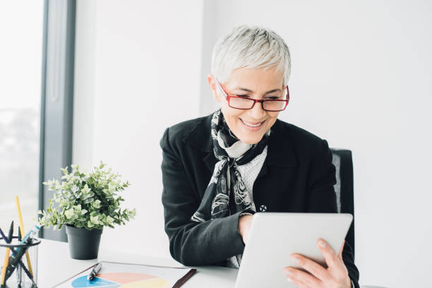 istock Happy mature business woman using digital tablet at work 965466568