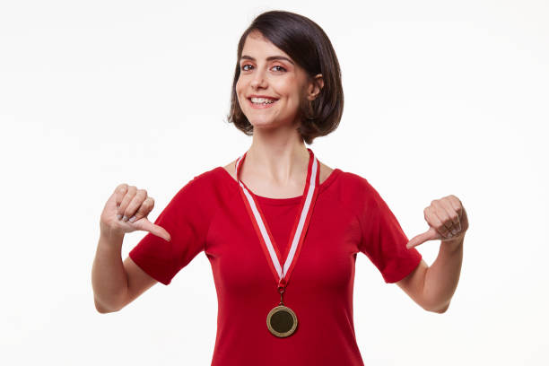 istock young woman holding gold medal 965474162