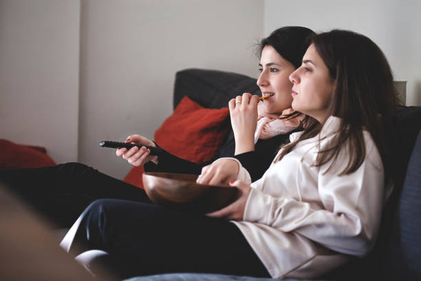 istock Young women watching TV at home 965477190