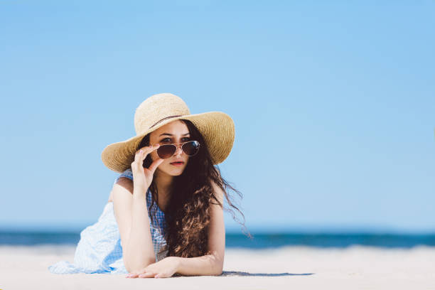 istock Pretty girl in straw hat laying on the sandy beach 965478224