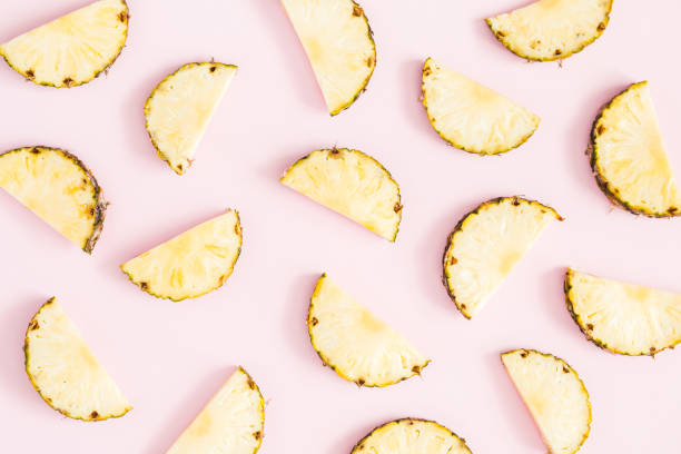 istock Pineapples on pastel pink background. Flat lay, top view 965488388