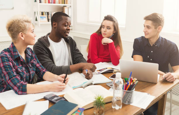 istock Group of diverse students studying at wooden table 965496590