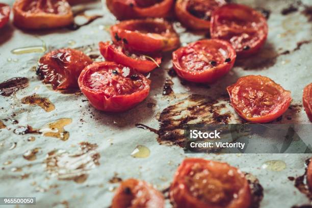 Rustic Style Roasted Cherry Tomatoes On White Baking Parchment Stock Photo - Download Image Now