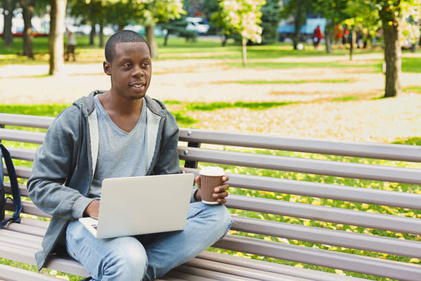 istock Concentrated man working on his laptop outdoors 965500596