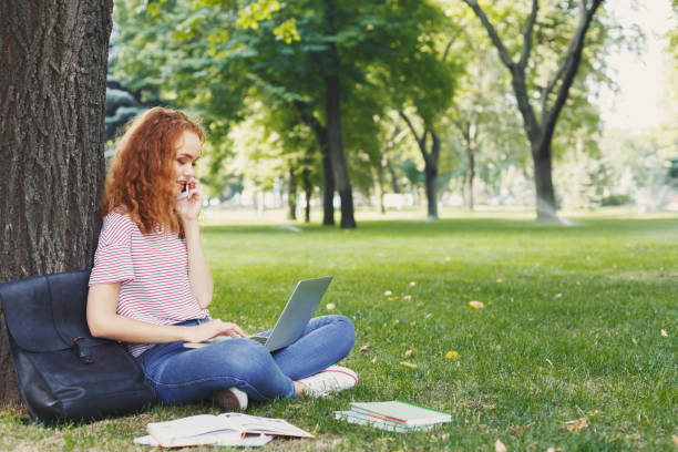 istock Attractive student with laptop and notebook outdoors 965503726